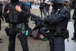 FILE - A protester from the initiative Querdenken, which opposes coronavirus restrictions, is detained by police during a demonstration in Frankfurt am Main, western Germany, Nov. 14, 2020.