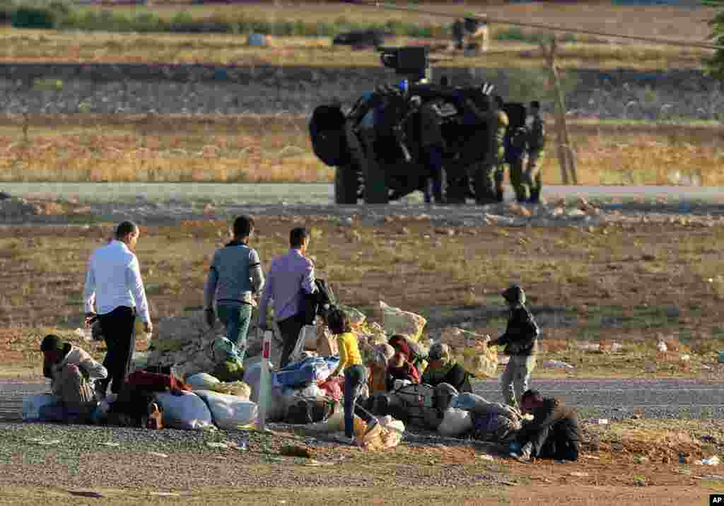 Syrian refugees from Kobani rest after arriving at the Turkey-Syria border crossing of Murstpinar near Suruc, Turkey, Oct. 1, 2014. 