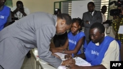 Burkina Faso incumbent President Blaise Compaore signs document after casting ballot at polling station during legislative, municipal elections, Ouagadougou, Dec. 2, 2012.