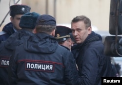 Russian opposition leader Alexei Navalny is escorted upon his arrival for a hearing after being detained at the protest against corruption, at the Tverskoi court in Moscow, Russia, March 27, 2017.