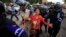 A protester is detained by Cambodian police officers during a rally in support of seven detained activists, in front of the Phnom Penh Municipal Court, in Phnom Penh, Nov. 11, 2014.