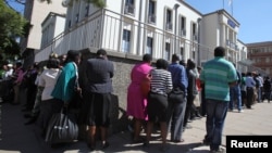 Residents queue to withdraw cash at a local bank in Harare, Zimbabwe, May 5, 2016.