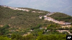 Thousands of Haitians flock to mount Calvaire Miracle, some with rocks balanced on their heads as form of penance during a Good Friday ritual that is among the country’s largest annual pilgrimages, in Ganthier, Haiti, April 14, 2017