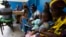 FILE - Women holding children wait for a medical examination at the health center in Gbangbegouine, Ivory Coast