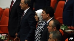 A group of ruling party lawmakers look on as newly elected legislators take their oaths during the new Turkish parliament’s opening session in Ankara, Turkey, June 23, 2015.