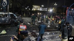 Police and security officers cordon off the area of a deadly bombing, in Lahore, Pakistan, Feb. 13, 2017.