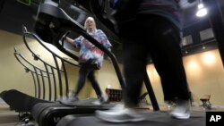 FILE - Gym members use as treadmill at a gym in Addison, Texas, Jan. 3, 2013. 