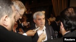 Leading Syrian dissident Riad Seif (C) speaks to the media at the meeting of the General Assembly of the Syrian National Council in Doha, November 8, 2012. 