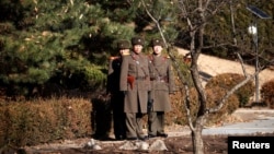 North Korean soldiers keep watch toward the south next to where a North Korean defected on Nov. 13, 2017, at Panmunjom inside the demilitarized zone, South Korea, Nov. 27, 2017.