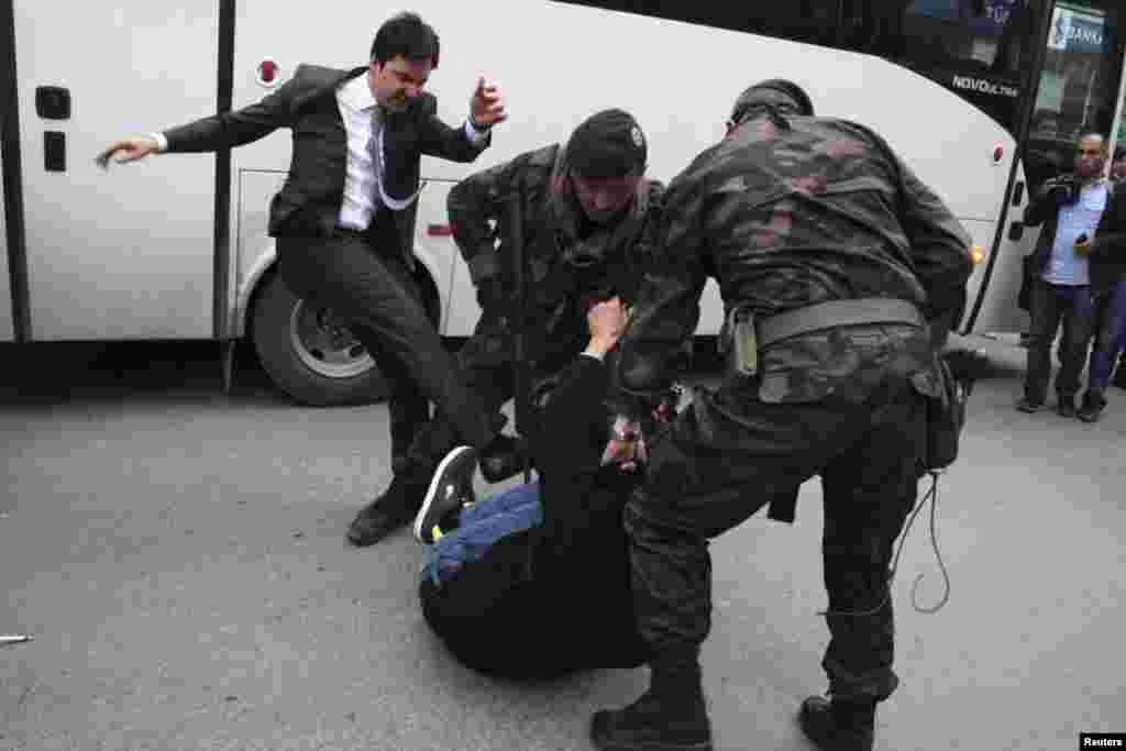 A protester is kicked by Yusuf Yerkel, advisor to Turkey&#39;s Prime Minister Tayyip Erdogan, as Special Forces police officers detain him during a protest against Mr. Erdogan&#39;s visit to Soma, May 14, 2014.