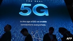 FILE - Attendees wait in line for a 5G exhibition at the Qualcomm booth during CES 2019 consumer electronics show, at the Las Vegas Convention Center in Las Vegas, Jan. 10, 2019.