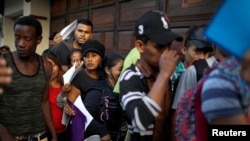 Cuban migrants wait outside the Mexican Commission for Refugee Assistance (COMAR) in Tapachula, Mexico, June 14, 2019. 