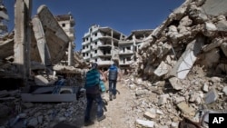 FILE - Children walk between destroyed buildings in the city of Homs, Syria, Feb. 26, 2016. The U.N. hopes to start talks on a political transition in the country next week.