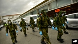 Members of the Military Emergency Unit, walking with special equipment to disinfect areas to prevent the spread of the coronavirus, arrive at Abando train station, in Bilbao, northern Spain, March 23, 2020. 