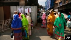 FILE - Indian Dawoodi Bohra women walk past others shopping for clothes in a Bohra neighborhood in Mumbai, India, on Feb. 21, 2016. The Dawoodi Bohra Muslim sect practices the ritual of "female circumcision," called female genital mutilation in a March 8, 2024, U.N. report.