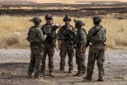 US soldiers stand at an oil field in the countryside of al-Qahtaniyah town in Syria's northeastern Hasakeh province near the Turkish border, on Aug. 4, 2020.