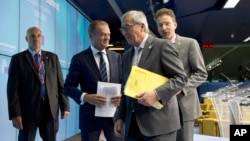 FILE - European Council President Donald Tusk (2nd l), European Commission President Jean-Claude Juncker and Dutch Finance Minister Jeroen Dijsselbloem speak with each other during a media conference after a meeting of eurozone heads of state, July 13, 2015.