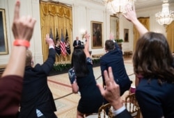 Reporters raise their hands as they shout questions to President Joe Biden after speaking about COVID-19 vaccinations in the East Room of the White House in Washington, July 29, 2021.
