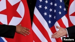 U.S. President Donald Trump and North Korea's leader Kim Jong Un meet at the start of their summit on the resort island of Sentosa, Singapore, June 12, 2018. 