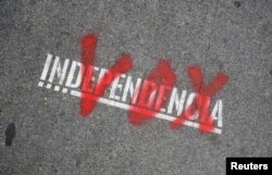 FILE - The name of the Spanish right-wing party Vox is sprayed over the graffiti stencil reading "Independence" on sidewalk in Barcelona, Spain, Dec. 12, 2018.