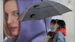 People wear masks to protect against coronavirus as they pass a shop in London, Wednesday, Feb. 3, 2021. (AP Photo/Kirsty Wigglesworth)