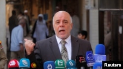 FILE - Iraqi Prime Minister Haider al-Abadi speaks to reporters in the Shi'ite holy city of Najaf, south of Baghdad, Oct. 20, 2014. 