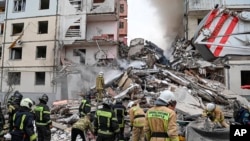 Servicios de emergencia rusos en el sitio de un edificio colapsado por un ataque de misiles ucranianos en Belgorod, Rusia, el 12 de mayo de 2024.