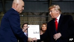 President Donald Trump shakes hands with Gen. Jay Raymond, after signing the letter of his appointment as the chief of space operations for U.S. Space Command, Andrews Air Force Base, Md., Dec. 20, 2019. 