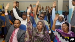 Somalia lawmakers raise their hands during a confidence vote on Prime Minister Abdiweli Sheikh Ahmed, at the Parliament Building in Mogadishu, Somalia, Dec. 6, 2014.