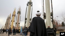 An Iranian cleric looks at domestically built surface-to-surface missiles at a military show marking the 40th anniversary of Iran's Islamic Revolution that toppled the U.S.-backed shah, at Imam Khomeini Grand Mosque, in Tehran, Iran, Feb. 3, 2019. 