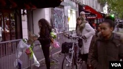 Parisians stop in front of the Bataclan concert hall, which reopens Saturday night. (L. Bryant/VOA)