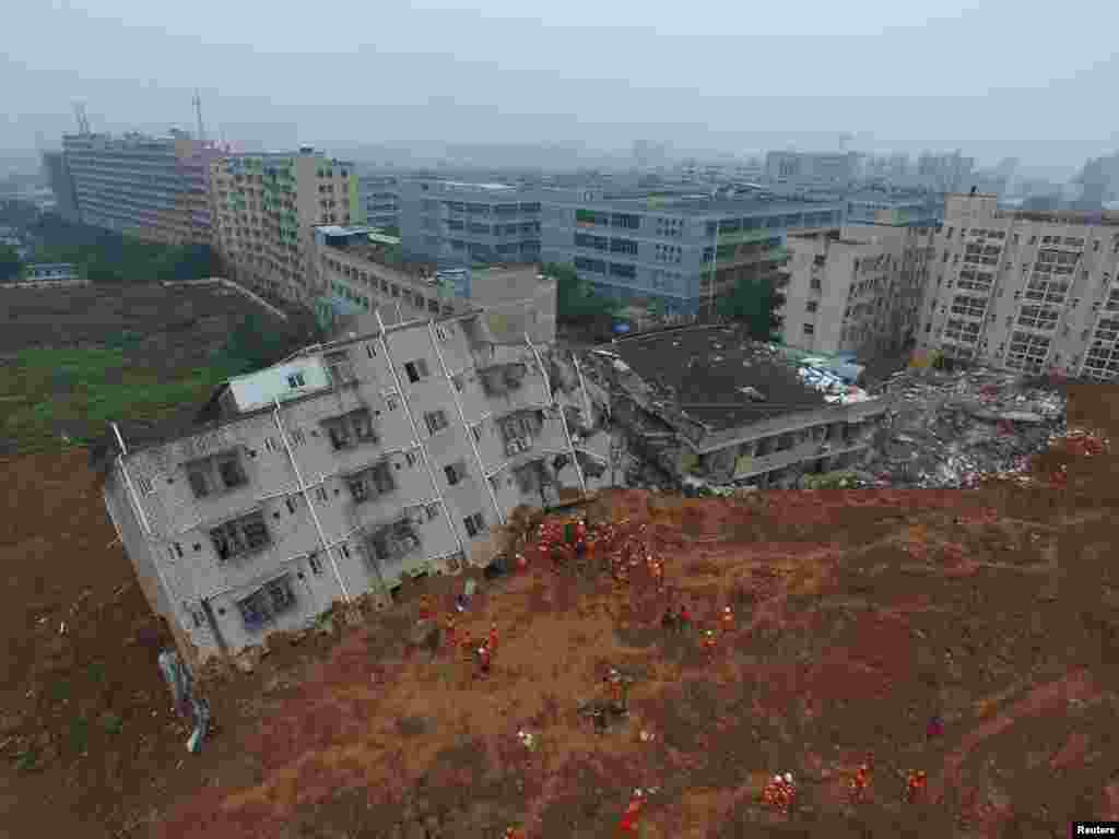 Firefighters search for landslide survivors among debris of destroyed buildings in Shenzhen, Guangdong province, China, Dec. 21, 2015.