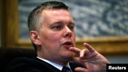 FILE - Polish Defense Minister Tomasz Siemoniak speaks to an interviewer in his office in Warsaw, April 10, 2014.