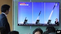FILE - A man watches a TV news program showing photos published in North Korea's Rodong Sinmun newspaper of North Korea's new type of cruise missile launch, at Seoul Railway station in Seoul, South Korea, June 9, 2017.