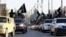 FILE - Islamic State fighters parade on military vehicles along the streets of Syria's northern Raqqa province.