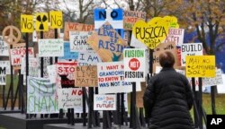 A visitor watches protest banners outside the UN Climate Change Conference in Bonn, Germany, Nov. 6, 2017.