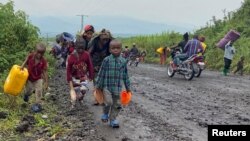 Warga membawa barang-barang mereka saat melarikan diri akibat konflik yang meluas setelah pemberontak M23 bergerak maju di sepanjang jalan dari Sake dekat Goma di provinsi Kivu Utara, Republik Demokratik Kongo (foto: dok). 