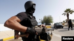 FILE - A member of the force assigned to protect Libya's unity government stands at the entrance to where the government has their offices, in Tripoli, Libya, April 14, 2016.