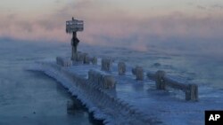 A harbor light is covered with snow and ice on the Lake Michigan at 39th Street Harbor, Jan. 30, 2019, in Chicago. 