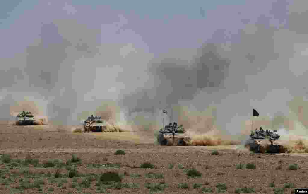 Israeli soldiers ride tanks after returning to Israel from Gaza.