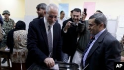 Muslim Brotherhood leader Mohamed Badie, second right, waits in line outside a polling place in Beni Suef, Egypt, to vote on a constitution drafted by supporters of President Mohamed Morsi, Dec. 22, 2012.