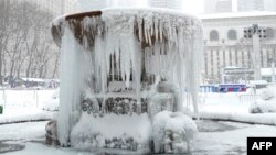 This photo is of a frozen fountain in New York City's Bryant Park during a winter storm on February 1, 2021. (Photo by TIMOTHY A. CLARY / AFP)