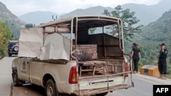 Security personnel stand near a damaged police vehicle at the site of a bomb explosion, in Malam Jabba at Swat district of Khyber Pakhtunkhwa province on Sept. 22, 2024. 