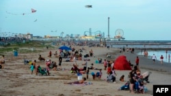 Beachgoers enjoy a day of sunshine at Galveston Beach on May 2, 2020 in Galveston, Texas, amid the coronavirus pandemic. - Texas beaches were ordered to be opened on May 1, 2020. In a statement, the City of Galveston said, "The City of Galveston's…