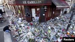 People mourn outside "Le Carillon" restaurant a week after a series of deadly attacks in Paris, Nov. 22, 2015. 