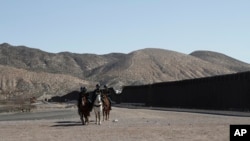 Border Patrol agents on horseback ride along a US-Mexico border fence on Jan. 31, 2020, in nearby town of Sunland Park, New Mexico.