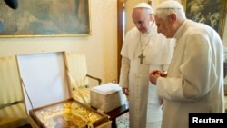 Pope Francis (L) exchanges a gift with Pope Emeritus Benedict XVI at the Castel Gandolfo summer residence, south of Rome, March 23, 2013.