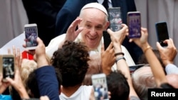 Pope Francis greets faithful as he arrives at the San Damaso courtyard for the weekly general audience at the Vatican, Sept. 23, 2020. 
