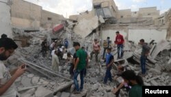 Men look for survivors under the rubble of a damaged building after an airstrike on Aleppo's rebel held Kadi Askar area in Syria, July 8, 2016.