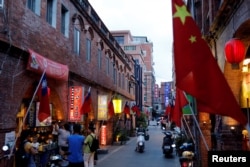 FILE - Chinese and Taiwanese flags are displayed around souvenir shops in Kinmen, Taiwan, Aug. 19, 2018.
